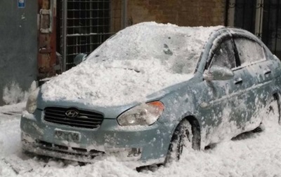 В центре Киева глыба снега сплющила автомобиль