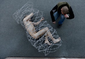 В знак протеста петербургский художник нагой обмотался колючей проволокой