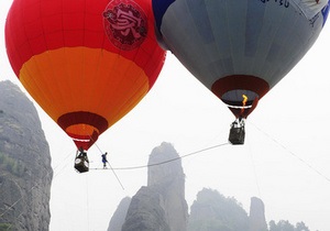 Китайский акробат прошел по канату, натянутому между двух воздушных шаров