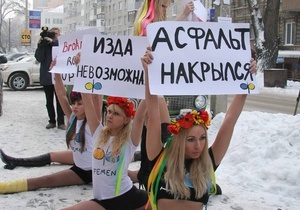 Асфальт накрылся: Днепропетровские активистки FEMEN сели на шпагат, чтобы  прикрыть ямы на дороге 