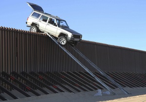 На границе США и Мексики джип нелегалов застрял на четырехметровом заборе