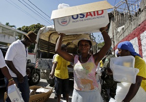 На Гаити процветает торговля гуманитарной помощью: рис набирают прямо из мешков с флагом США