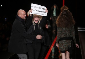 Неделя моды в Милане: активистка выбежала на подиум с плакатом Ваша мода - их смерть
