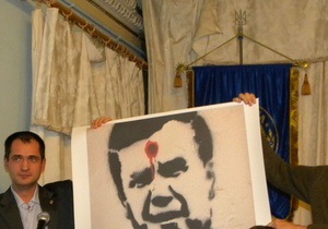 На языковом форуме в Киеве растянули баннер с изображением Януковича с красной точкой на лбу
