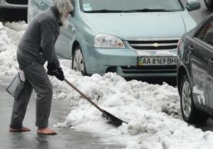 В центре Киева неизвестный мужчина босиком убирает снег