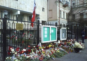 Люди несут цветы к польскому посольству в Киеве
