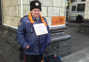 Один чоловік у помаранчевому шарфі святкує річницю революції на Майдані