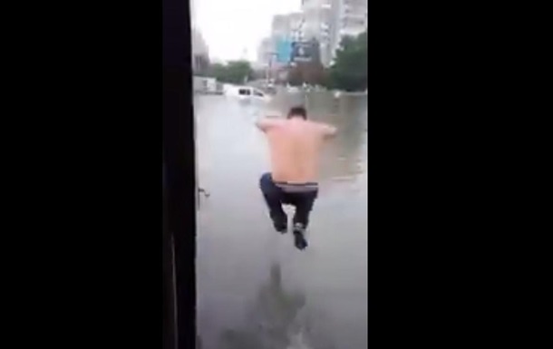 Зливи в Одесі: чоловік стрибнув у величезну калюжу
