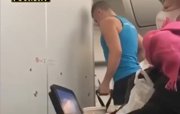 Мужчина занялся спортом на борту летящего самолета