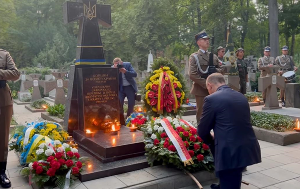 Duda kneels in front of the monument to UNR soldiers